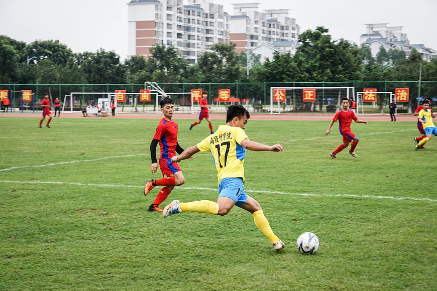 Soccer player kicking ball on green field during match
