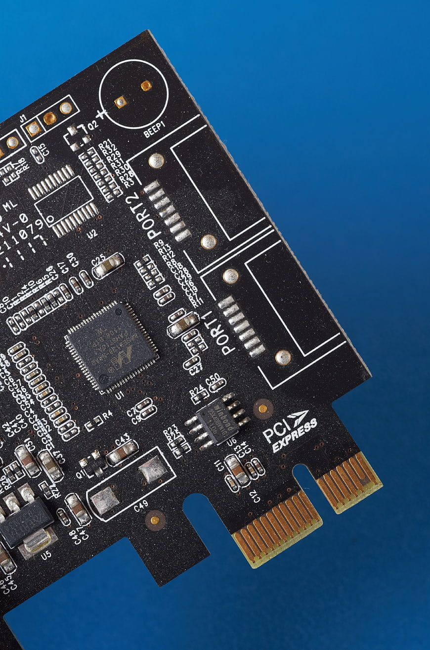 Close-up of black PCI Express circuit board on blue background
