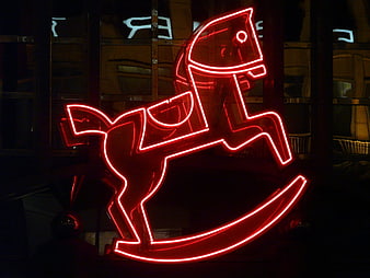 Red Neon Rocking Horse Sign Against Dark Nighttime Background