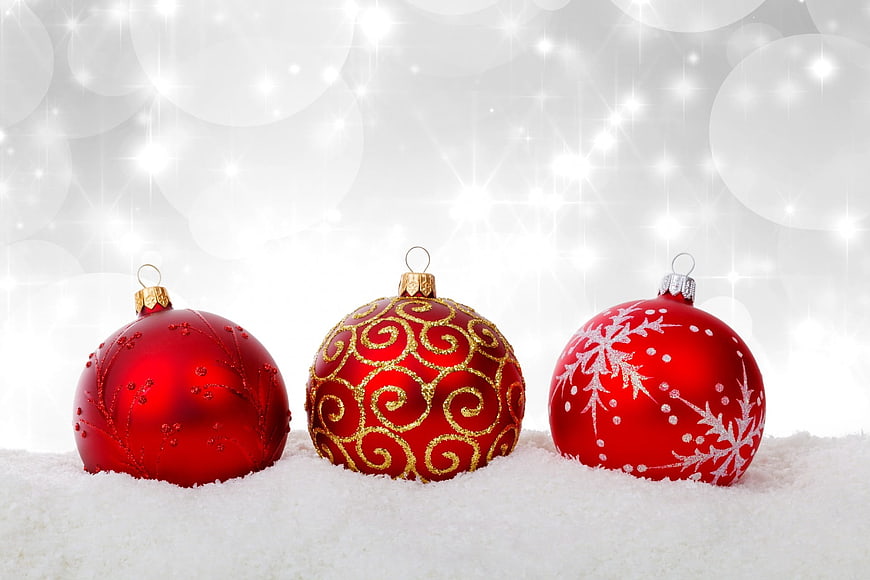 Three Red Christmas Ornaments in Snow with Sparkling Background