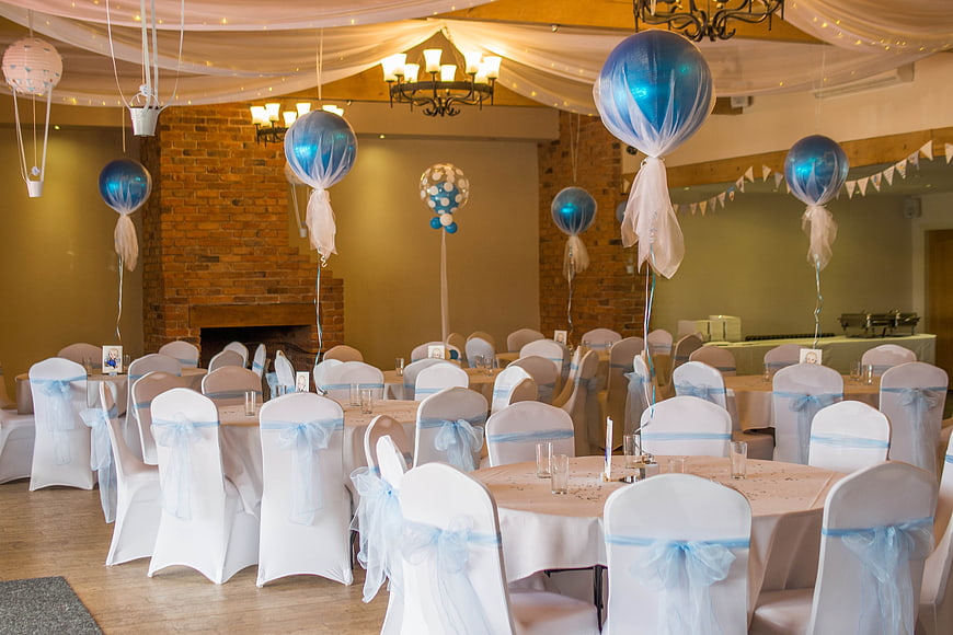 Blue and white christening party room with balloons and chair covers