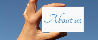 Hand holding white card with About us text against blue sky