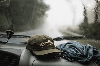 Vintage Baseball Cap on Car Dashboard in Rain