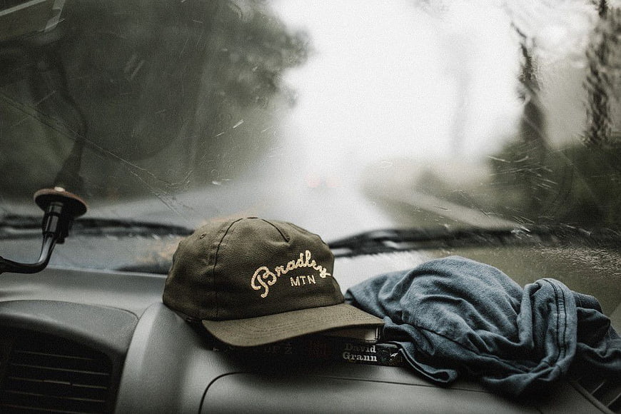 Vintage Baseball Cap on Car Dashboard in Rain