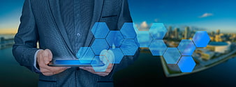 Businessman holding tablet with blue hexagon technology overlay