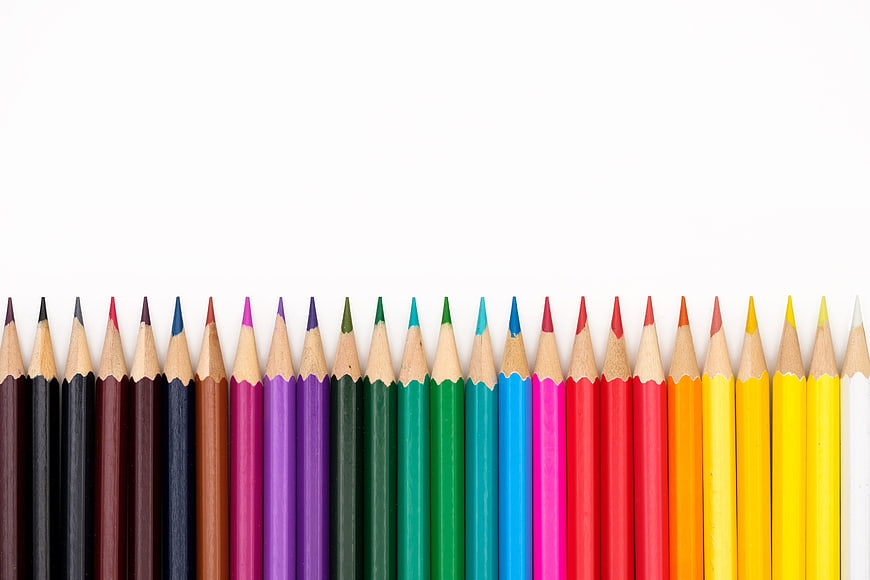 Row of Multicolored Pencils on White Background
