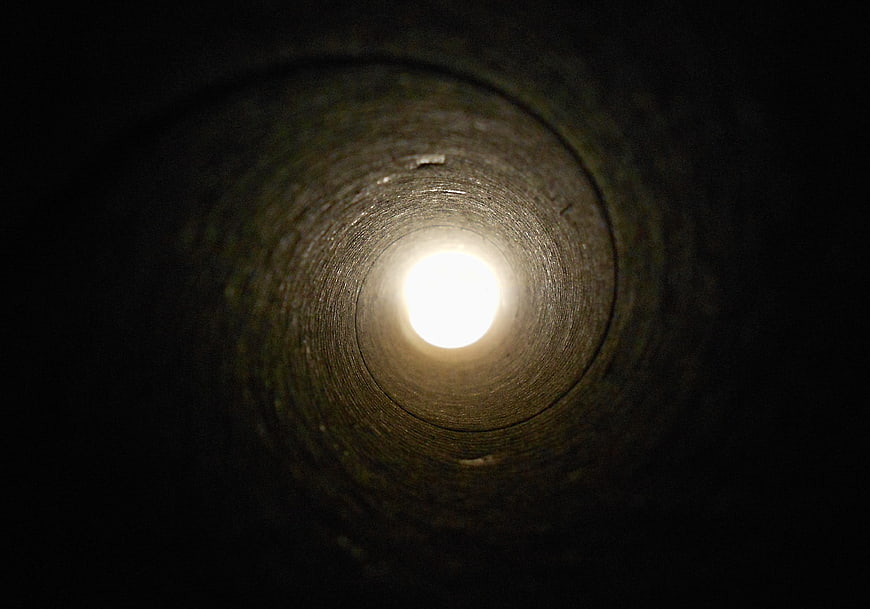 Illuminated Concrete Tunnel Interior With Bright Exit Light
