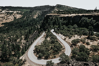 Aerial view of winding mountain road through forest