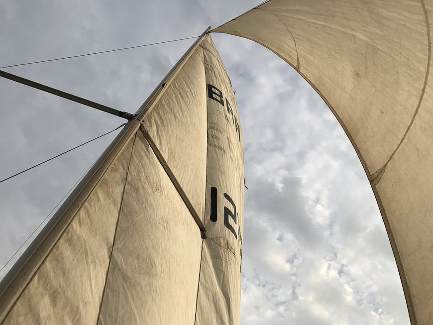 Low angle view of sailboat sails against cloudy sky