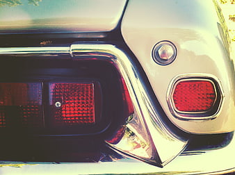Close-up of vintage car taillight and chrome bumper