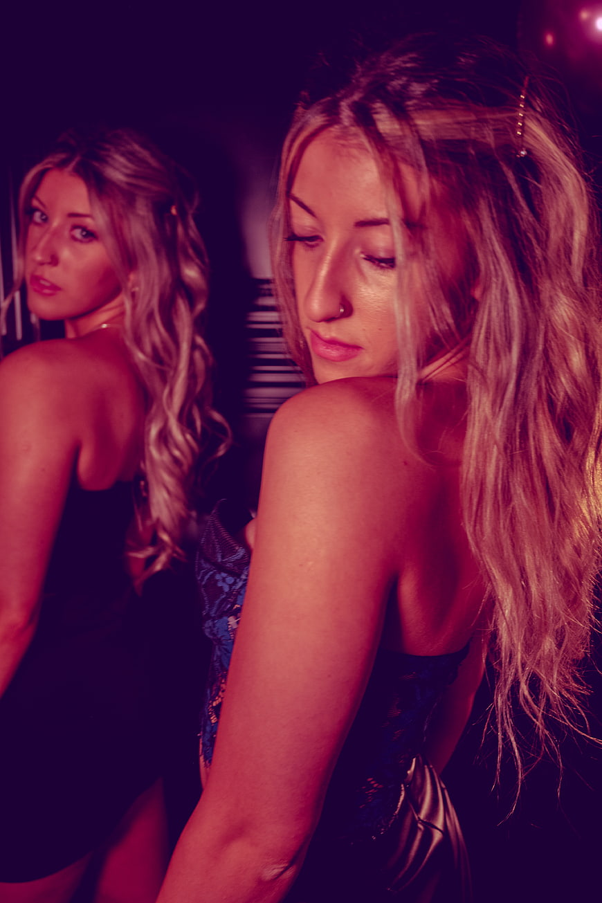 Two blonde women in a nightclub with purple lighting