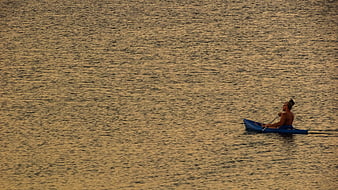 Man Kayaking on Golden Water at Sunset