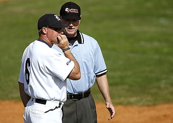 Baseball coach and umpire discussing on the field