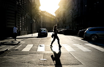 Woman Crossing Street in Golden Hour Sunlight