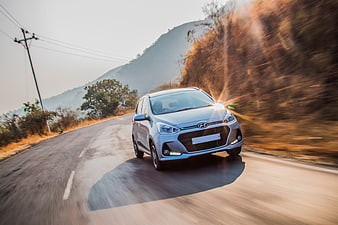 Silver Hyundai i10 driving on a rural road with motion blur