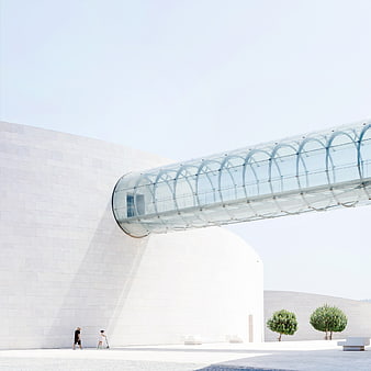Modern white architecture with glass bridge and people