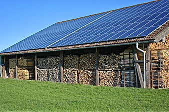 Solar panels on barn roof with stacked firewood
