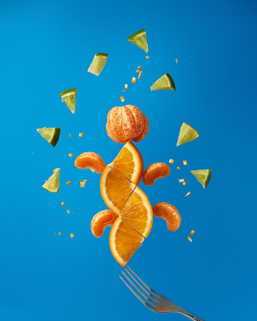 Floating citrus fruits and lime slices on blue background