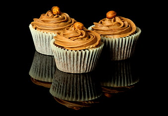 Three Hazelnut Cupcakes with Reflection on Black Background