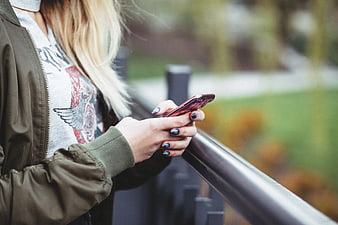 Woman using smartphone outdoors with blurred background