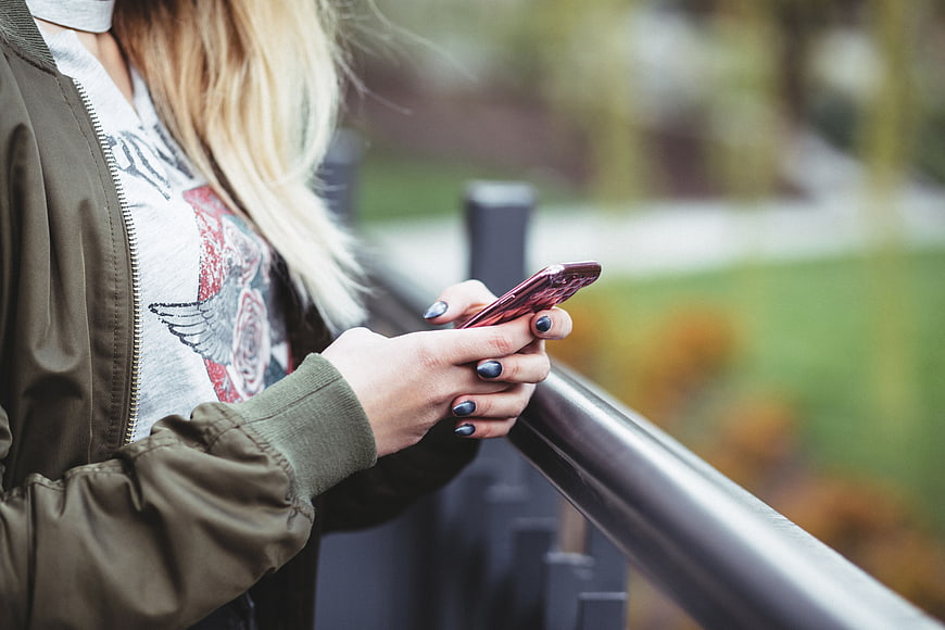 Woman using smartphone outdoors with blurred background