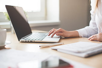 Woman Typing on Laptop in Bright Office Workspace