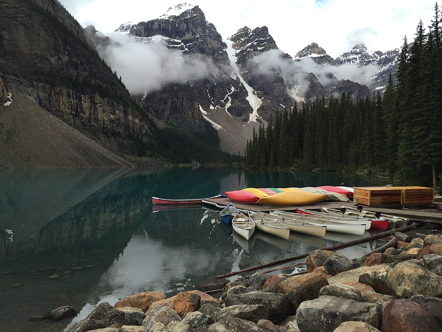 Colorful Canoes Docked at Mountain Lake with Reflections