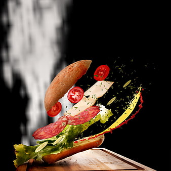 Exploding sandwich ingredients in mid-air on wooden board