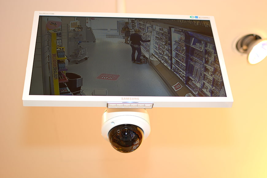 Security camera and monitor displaying supermarket surveillance footage