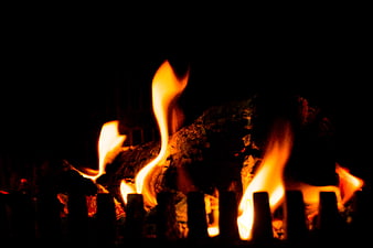 Close-up of burning logs in a dark fireplace