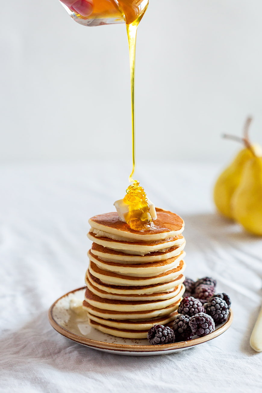 Stack of pancakes with honey and blackberries