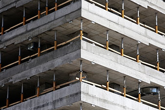 Concrete building under construction with scaffolding supports