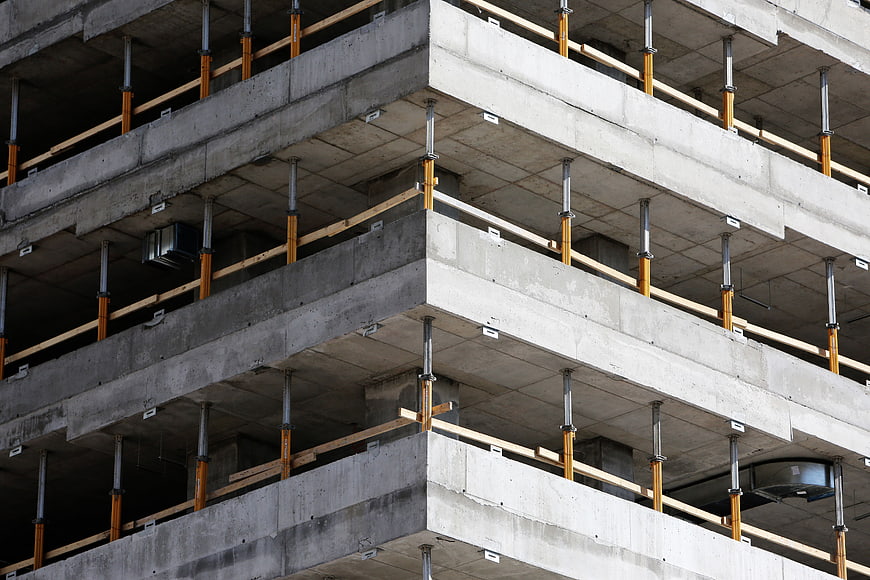 Concrete building under construction with scaffolding supports