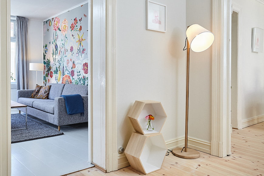 Modern apartment interior with floral wallpaper and hexagonal shelves