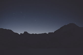 Silhouette of mountains under a starry night sky