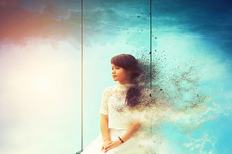 Woman dissolving into particles against blue sky background