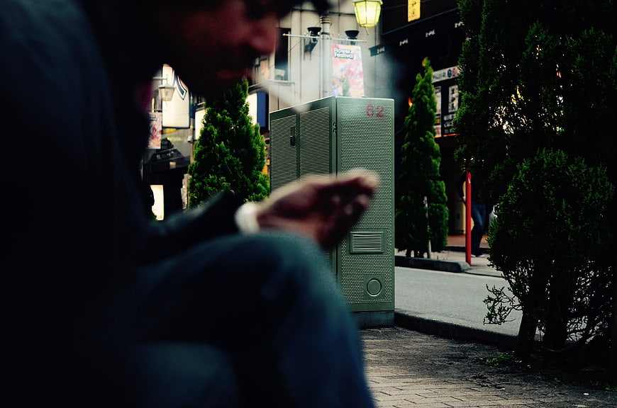 Man Smoking Cigarette on Urban Street at Night