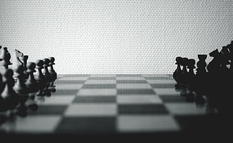 Black and white chess pieces on a board with blurred background