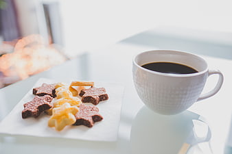 White coffee cup and star-shaped cookies on a table