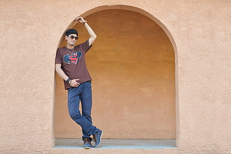 Stylish young man posing in an arched niche