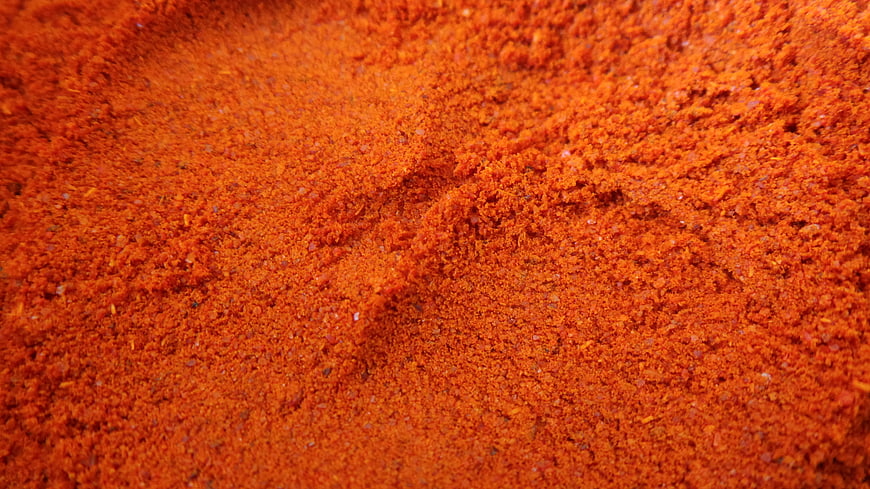 Close-up texture of vibrant red chili powder seasoning