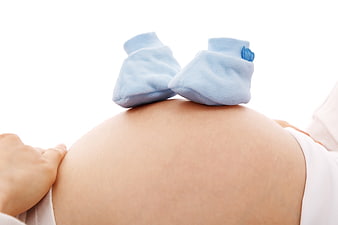 Blue baby socks on pregnant belly