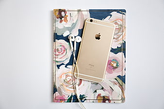 Gold iPhone and Earphones on Floral Notebook Flat Lay