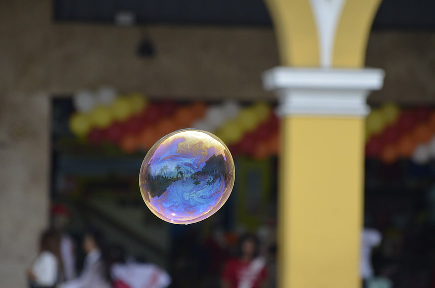 Iridescent soap bubble reflecting colorful scene