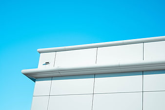 Modern white building facade against clear blue sky