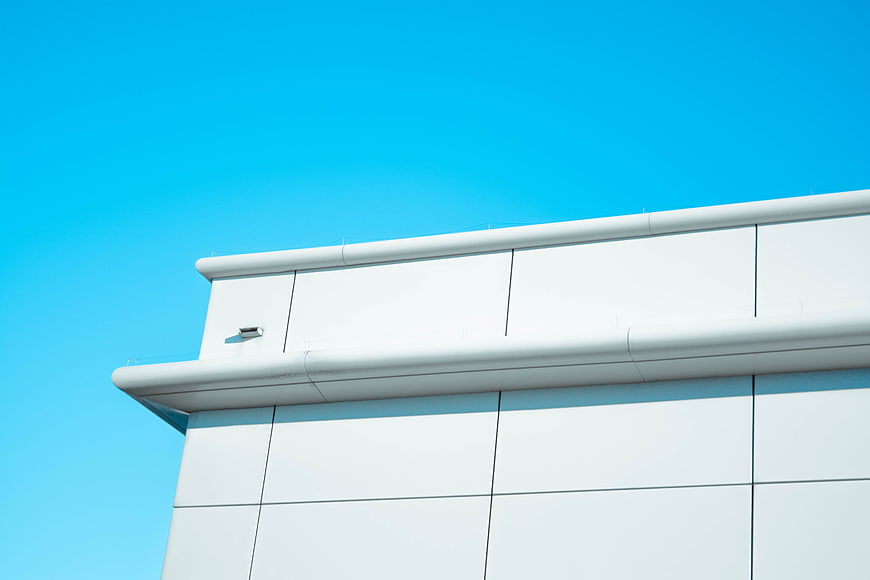 Modern white building facade against clear blue sky