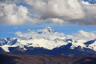Majestic Snow-Capped Mountain Peak with Clouds and Blue Sky