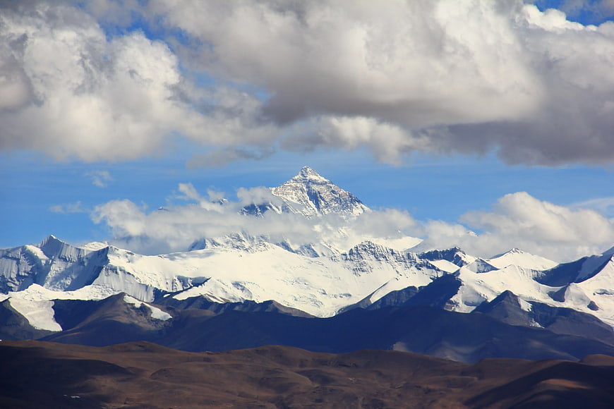 Majestic Snow-Capped Mountain Peak with Clouds and Blue Sky
