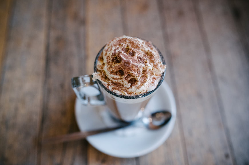 Overhead view of hot chocolate with whipped cream and cocoa powder