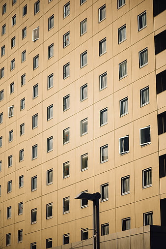 Modern beige apartment building facade with grid of windows